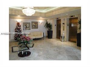 A lobby features a seating area, two elevators, a Christmas tree, and marble flooring — 9195 Collins Ave # 614, Surfside FL 33154, SURFSIDE, FL