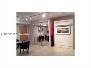 A room features a white Murphy bed, mirrored closet doors, and a small dining area — 9195 Collins Ave # 614, Surfside FL 33154, SURFSIDE, FL