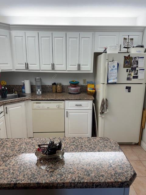 A kitchen features white cabinetry, granite countertops, a dishwasher, and a white refrigerator — 440 Pine Glen Lane # 1, FL 33463, FL