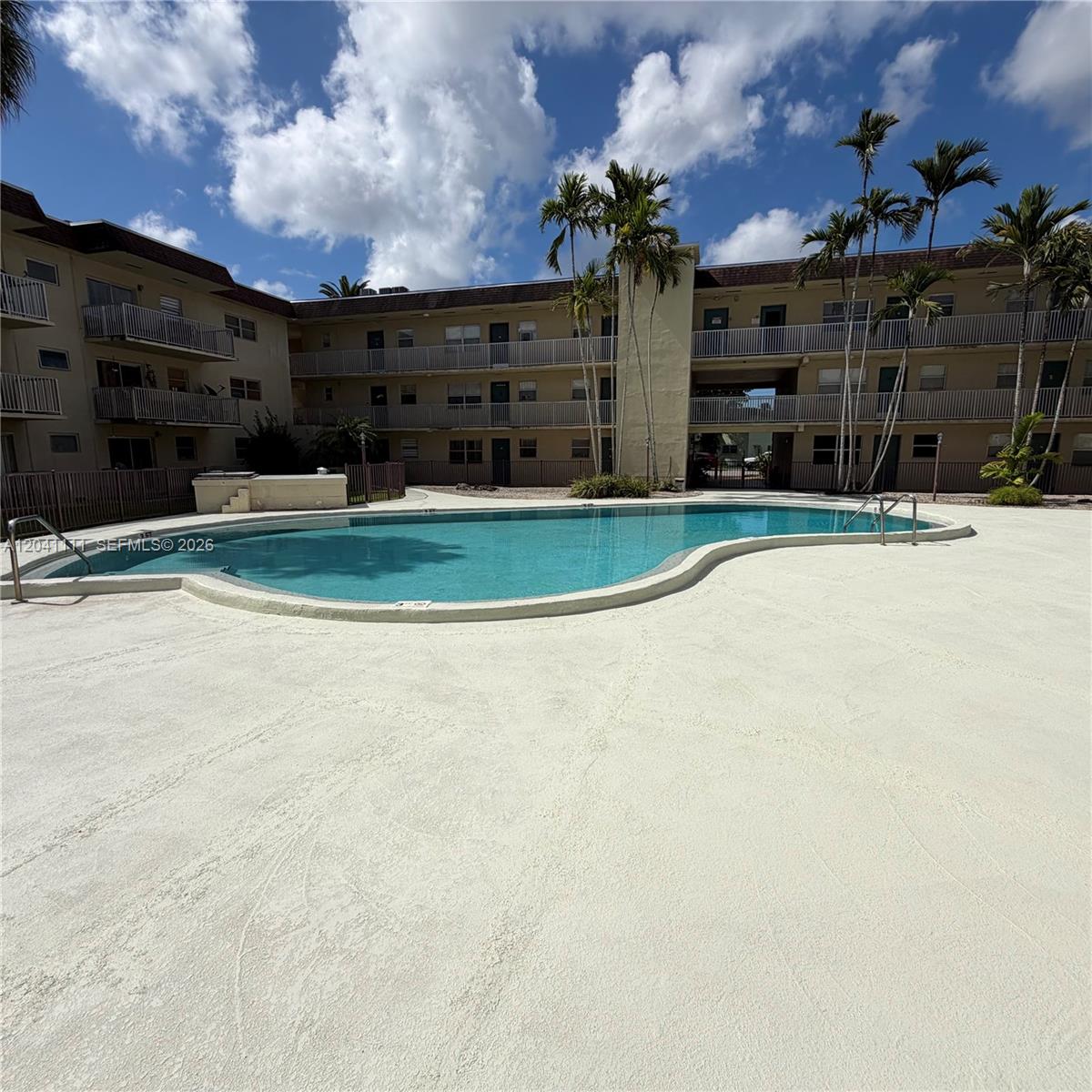An outdoor swimming pool is situated in the courtyard of a multi-story apartment complex — 7505 SW 82nd St # 206, Miami FL 33143, MIAMI, FL
