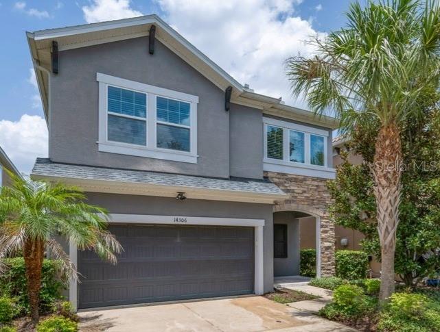 A two-story house with a gray stucco exterior, stone accents, and a two-car garage — 14306 BARRINGTON STOWERS DRIVE, LITHIA, FL