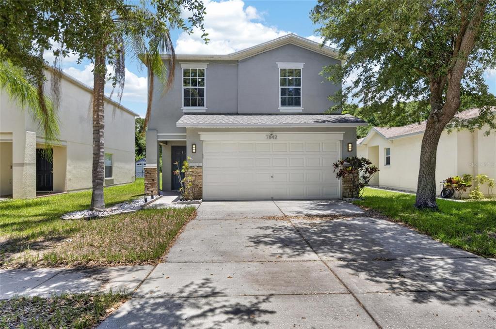 A two-story gray house with a two-car garage and a concrete driveway — 7842 CARRIAGE POINTE DRIVE, GIBSONTON, FL