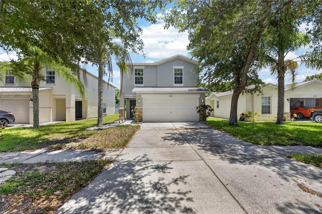 A two-story gray house with a two-car garage and a concrete driveway — 7842 CARRIAGE POINTE DRIVE, GIBSONTON, FL