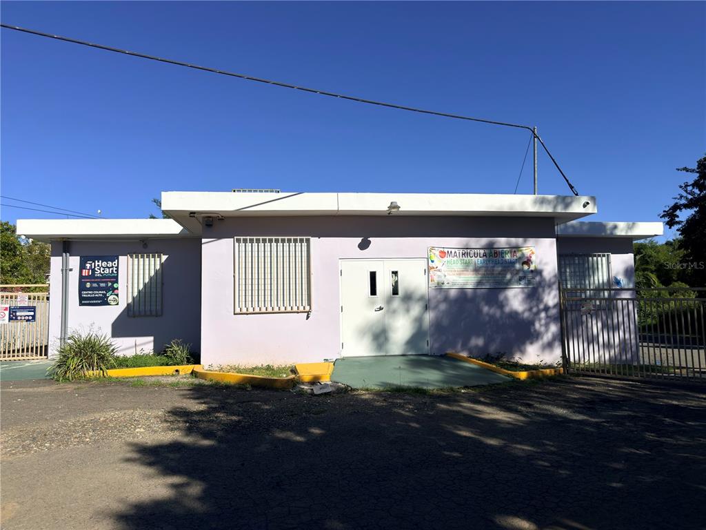 A light purple, single-story Head Start building with a double door entrance and metal fencing — PR 181 Km 4.8 BO. LAS CUEVAS, TRUJILLO ALTO, PR