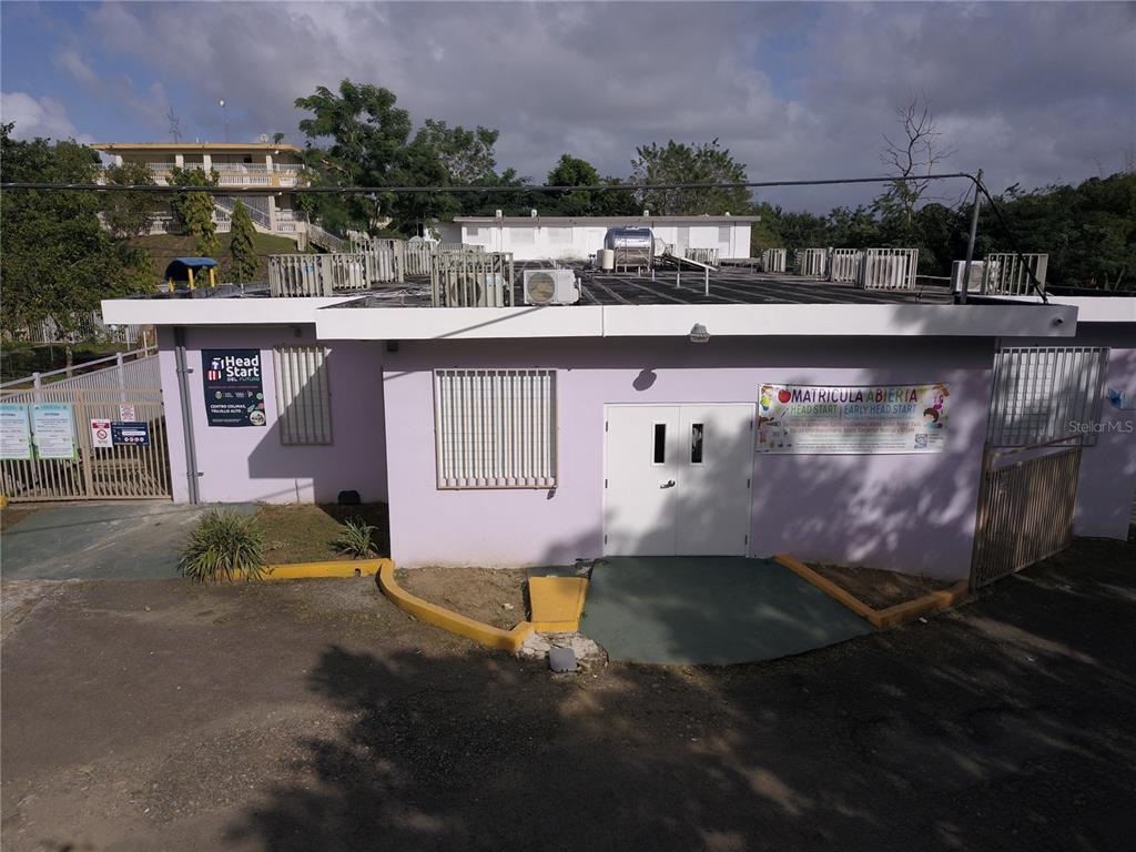 A light purple single-story building with a flat roof and a double-door entrance — PR 181 Km 4.8 BO. LAS CUEVAS, TRUJILLO ALTO, PR