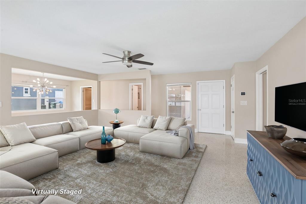 A living room features a large sectional sofa, a blue console, and light-colored flooring — 563 EASTVIEW ROAD, LARGO, FL