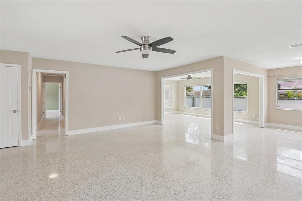 A bright, open-concept living area features polished terrazzo flooring, neutral walls, and a ceiling fan — 563 EASTVIEW ROAD, LARGO, FL