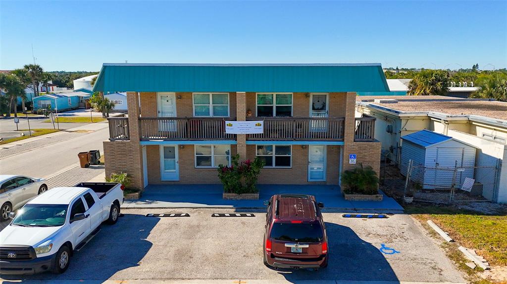 A two-story brick building with a teal metal roof and a wooden balcony — 212 S DAYTONA AVENUE UNIT 2, FLAGLER BEACH, FL