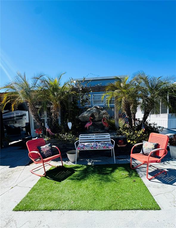 A patio area features a white bench, two orange chairs, and artificial turf — 411 ST GEORGE DRIVE, DAVENPORT, FL