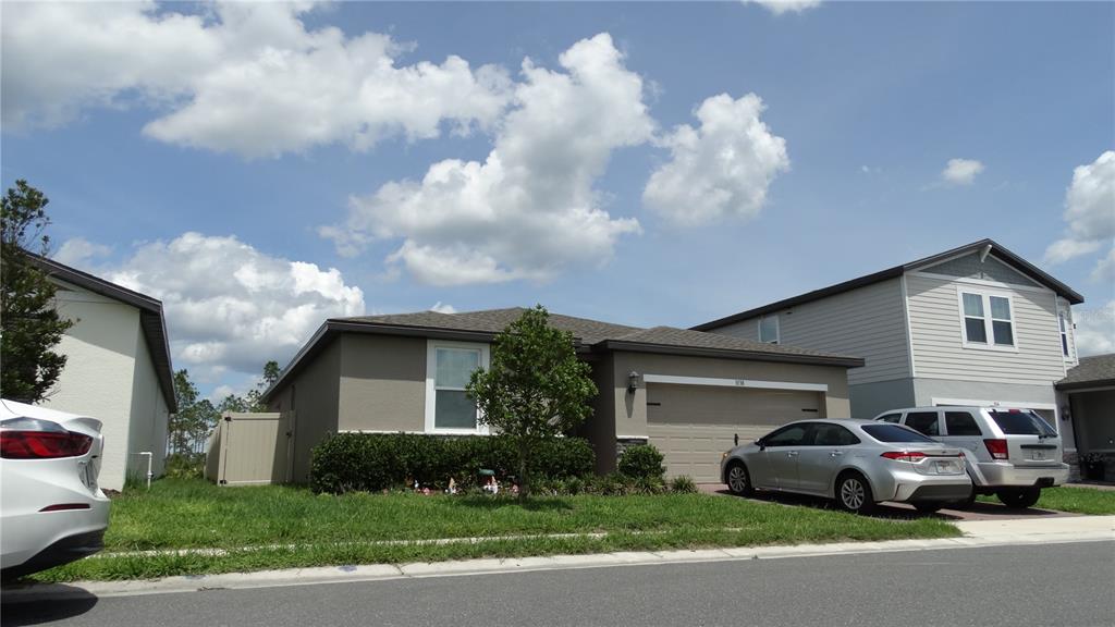 A one-story suburban house with a tan exterior, a two-car garage, and a parked car — 3138 VICEROY COURT, KISSIMMEE, FL
