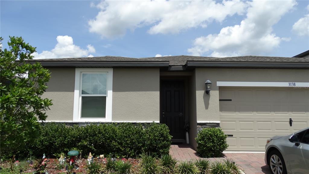 A single-story house exterior features a beige stucco facade, a garage, and a front garden — 3138 VICEROY COURT, KISSIMMEE, FL