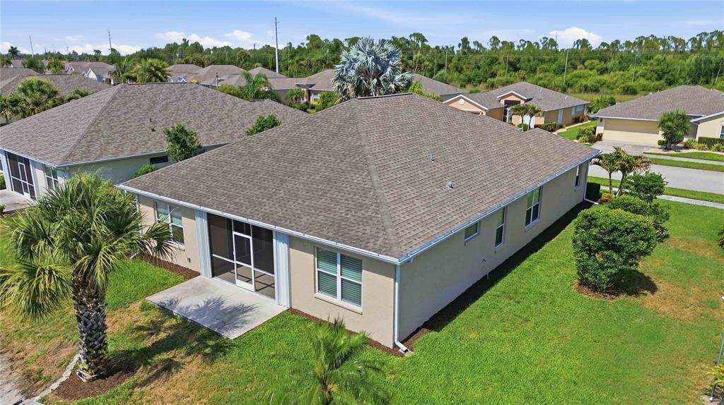 An aerial view of a single-story house with a screened-in patio and a shingled roof — 409 TOMOKA DRIVE, ENGLEWOOD, FL