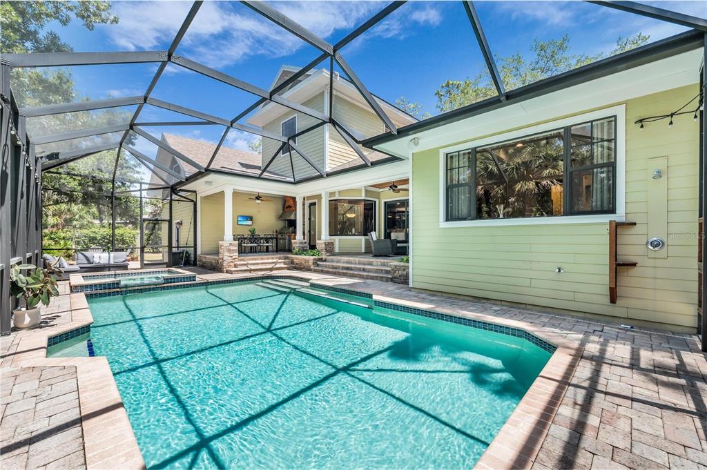 A swimming pool and spa are enclosed by a screened lanai next to a house — 5911 RIVER FOREST CIRCLE, BRADENTON, FL