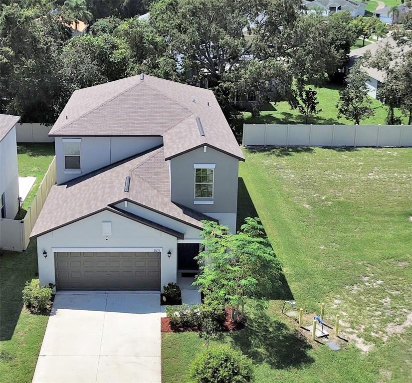 An aerial view shows a two-story house with a gray exterior, brown roof, and garage — 13678 SEA BRIDGE DRIVE, HUDSON, FL