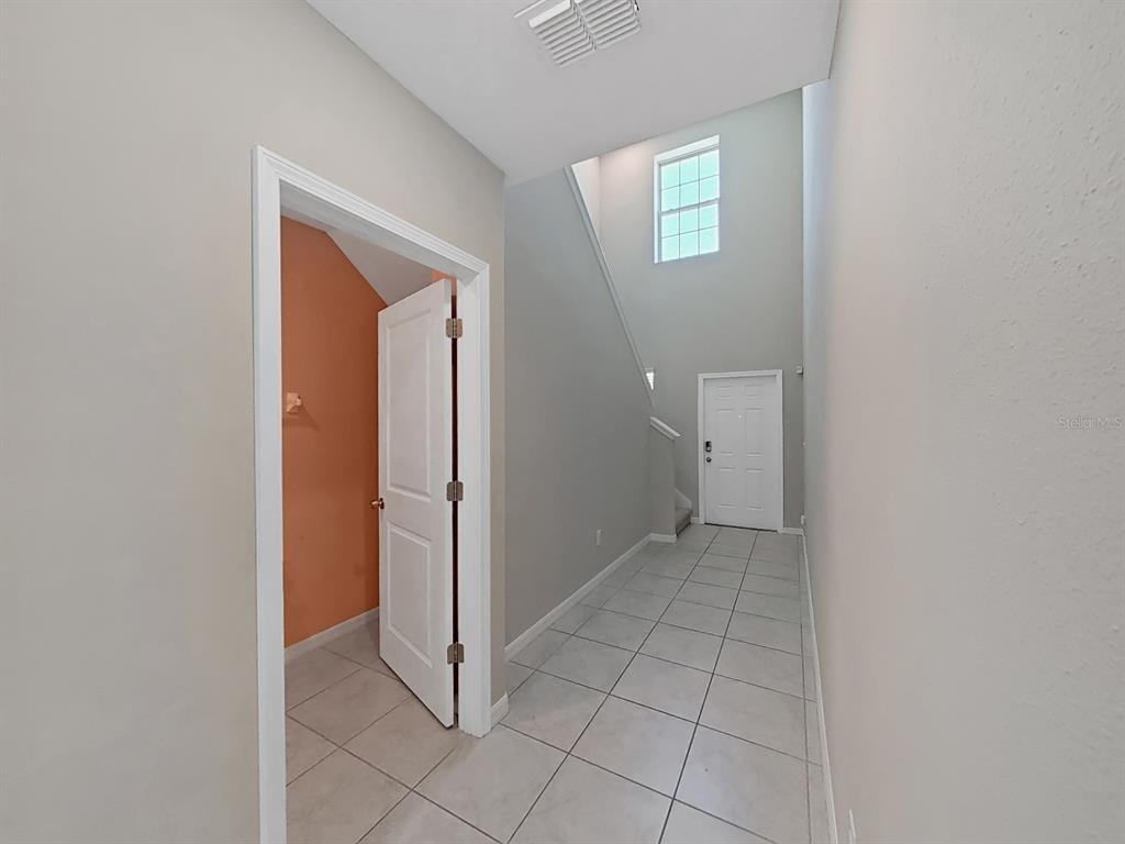 A tiled entryway features a high ceiling, a white door, and an open doorway — 13678 SEA BRIDGE DRIVE, HUDSON, FL