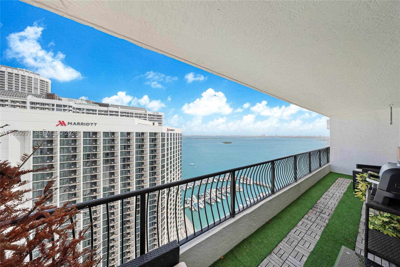 A balcony with artificial turf and a view of a hotel, marina, and bay — 555 NE 15th St # 33G, Miami FL 33132, MIAMI, FL