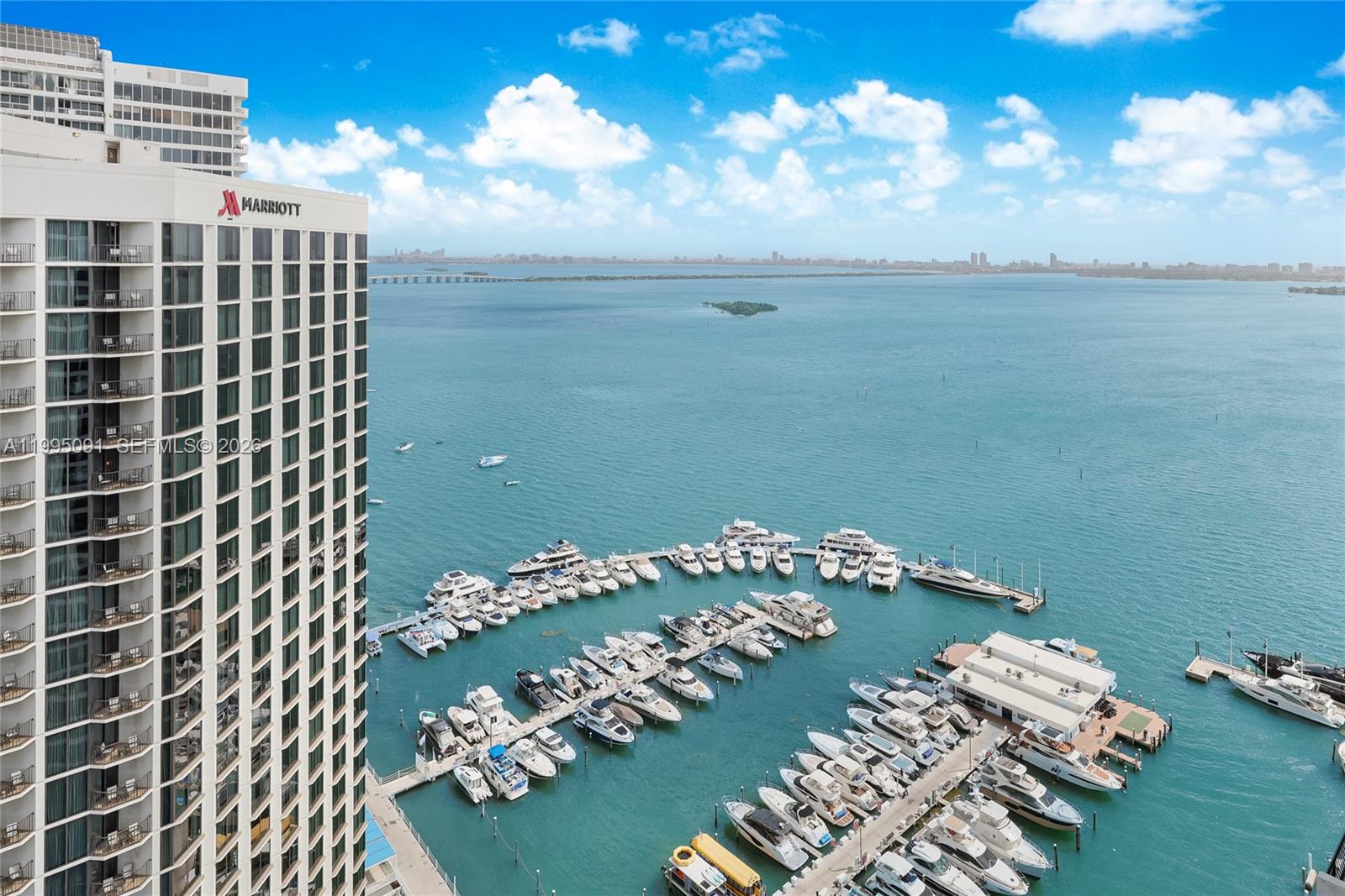 An aerial view shows a high-rise Marriott hotel overlooking a marina filled with numerous boats — 555 NE 15th St # 33G, Miami FL 33132, MIAMI, FL