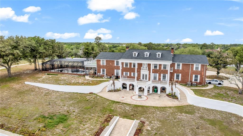An aerial view of a large brick house with a pool enclosure and retaining walls — 1585 S CARPENTER ROAD, TITUSVILLE, FL