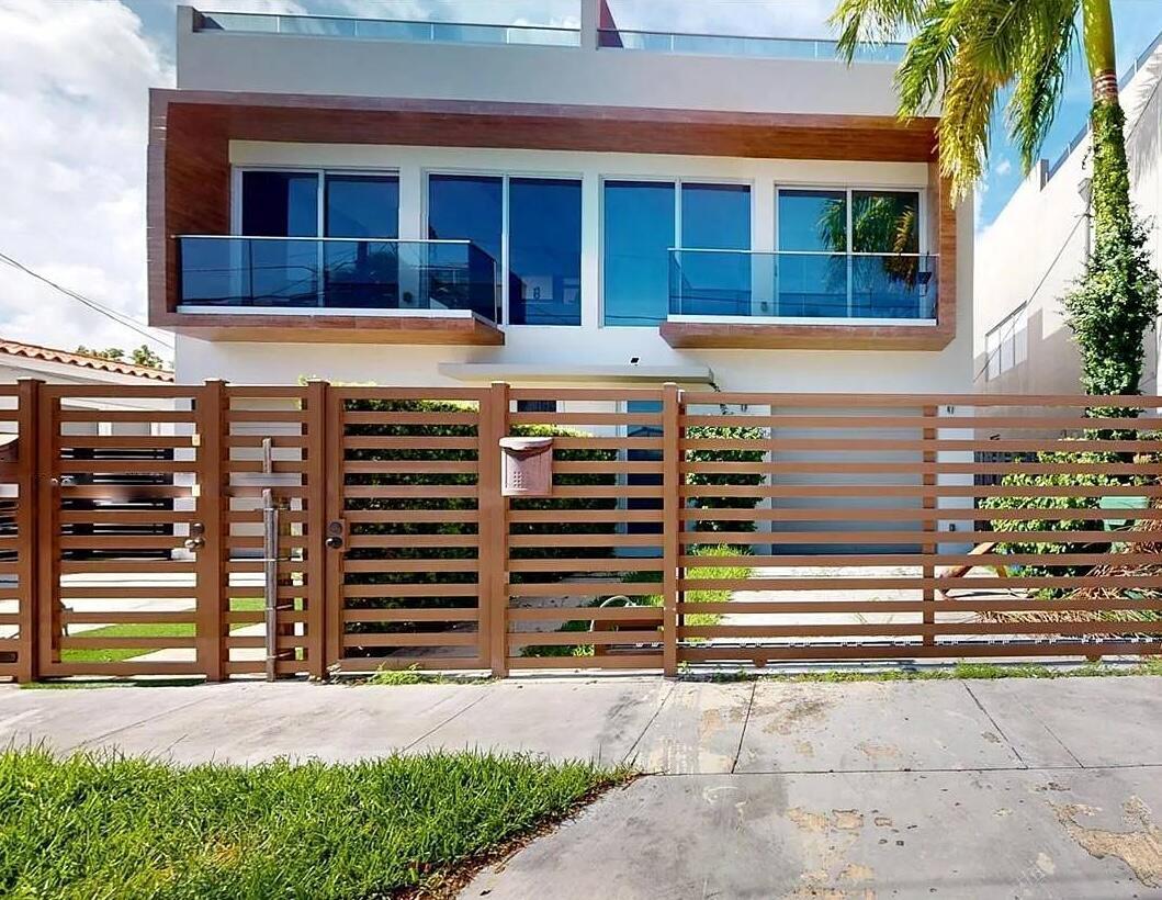 A modern two-story house features a wood-paneled facade, glass balconies, and a horizontal slat fence — 3091 SW 21st Street, Miami FL 33145, MIAMI, FL