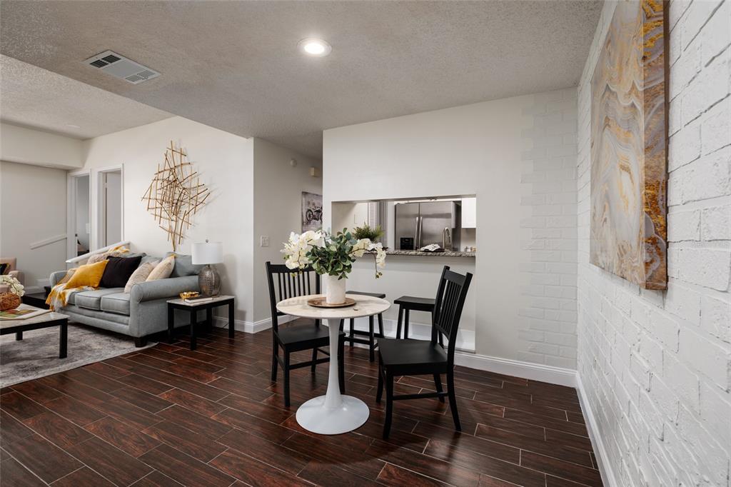 A dining area with a round table and black chairs sits before a kitchen pass-through — 4405 W FAIR OAKS AVENUE UNIT 21, TAMPA, FL