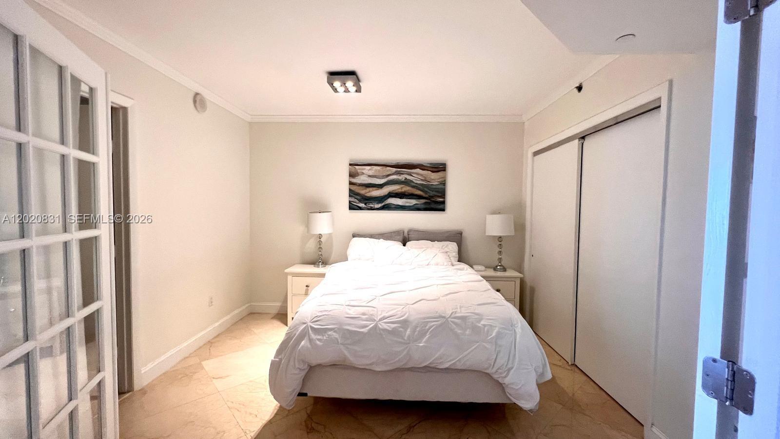 A bedroom features a bed with white bedding, two nightstands, and tile flooring — 1830 S Ocean Dr # 2204, Hallandale Beach FL 33009, HALLANDALE BEACH, FL