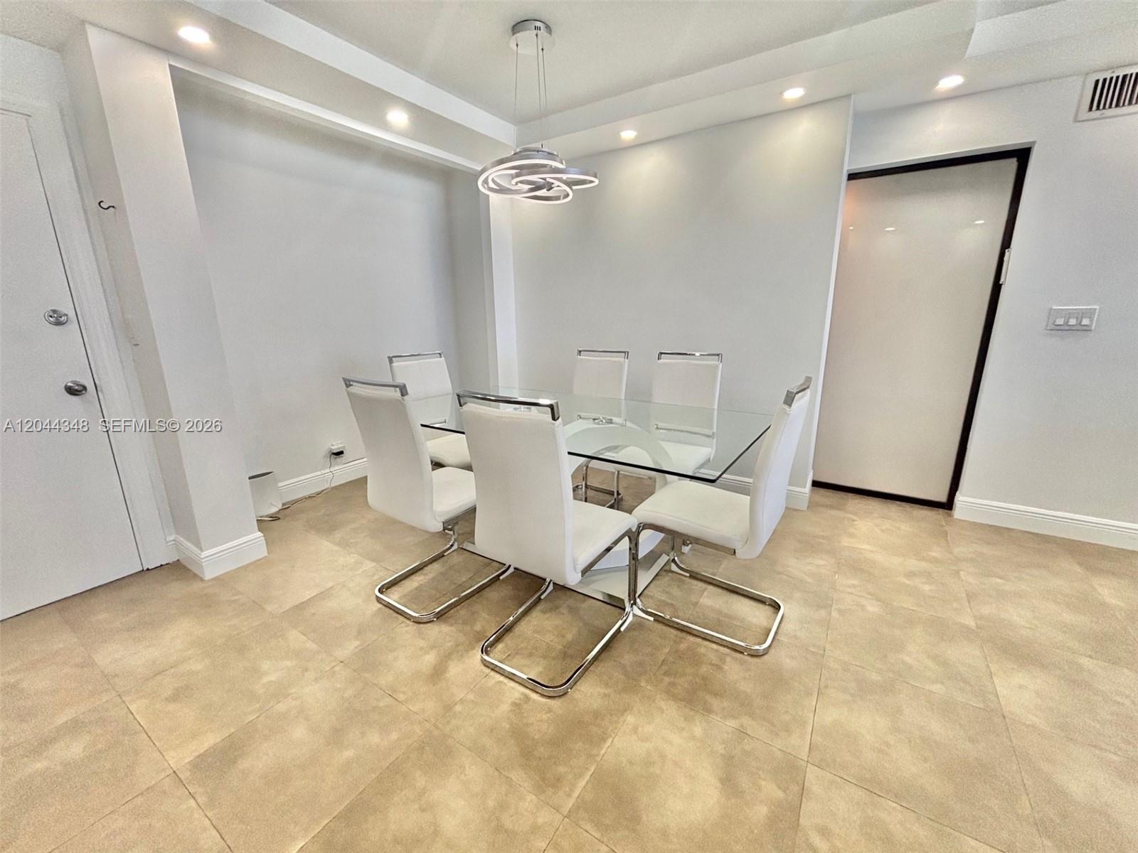 A dining room features a glass table, six white chairs, and a modern pendant light — 2030 S Ocean Dr # 423, Hallandale Beach FL 33009, HALLANDALE BEACH, FL