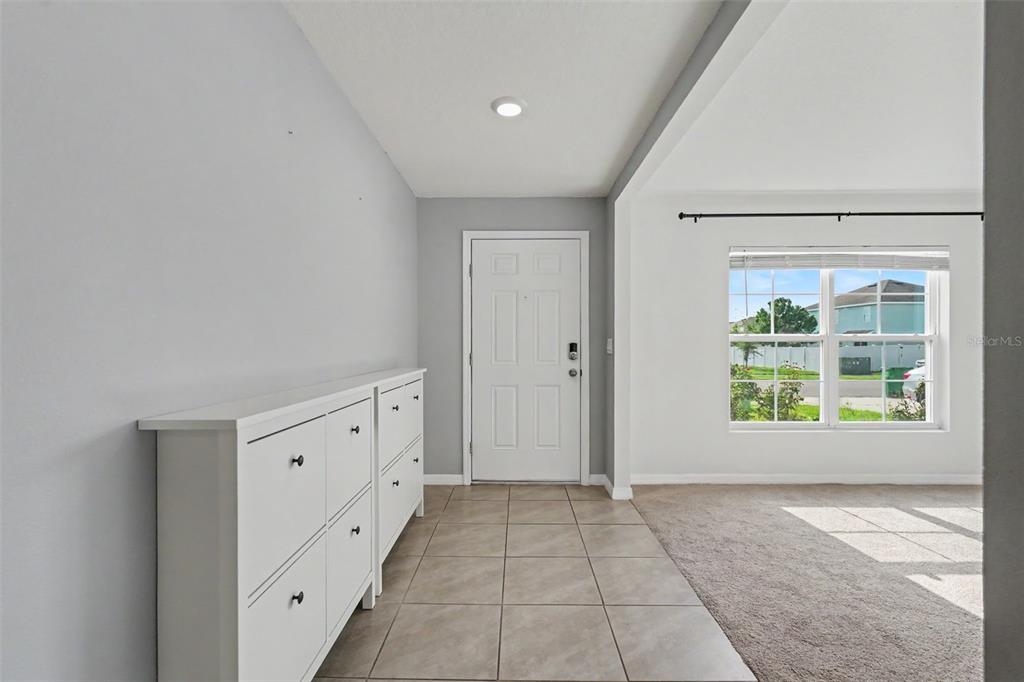 An entryway features tile flooring, a white shoe cabinet, and a white front door — 36851 GOFFAUX LOOP, ZEPHYRHILLS, FL