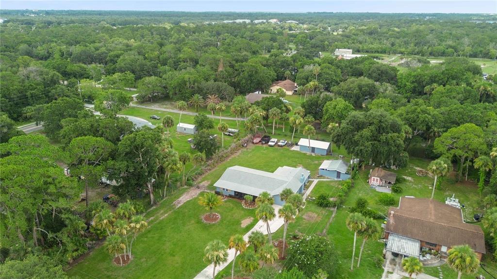 An aerial view shows a single-story house with a large yard, trees, and outbuildings — 4105 RECTOR ROAD, COCOA, FL