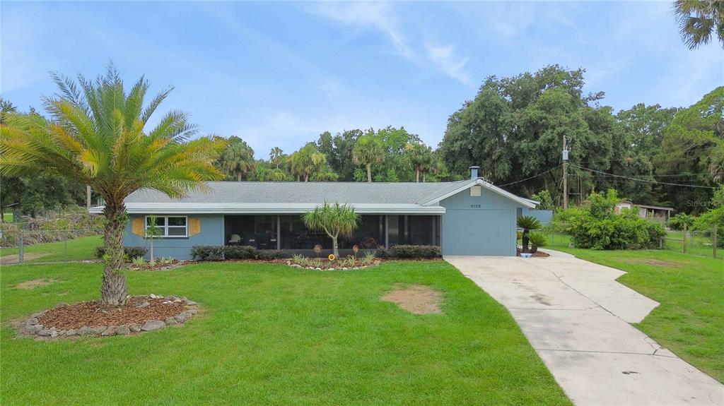 A single-story blue house with a screened-in porch and a concrete driveway — 4105 RECTOR ROAD, COCOA, FL