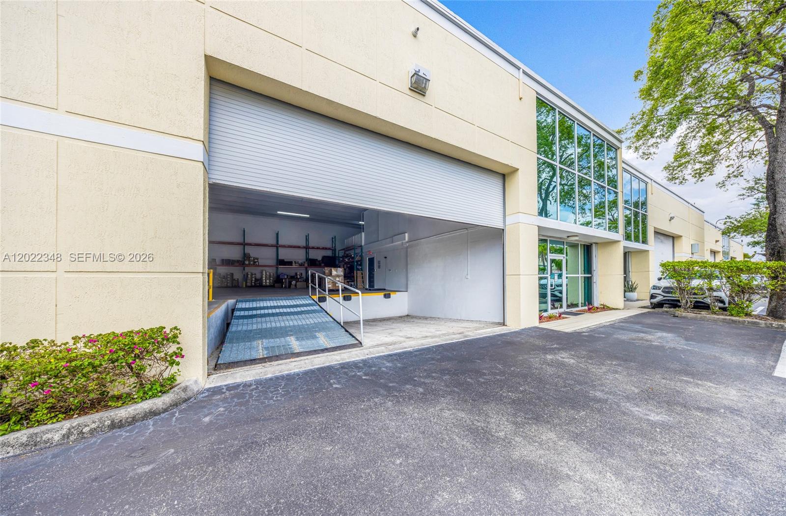 An exterior view of a commercial building featuring a loading dock and glass storefront — 8009 NW 29th St # 8009, Doral FL 33122, DORAL, FL