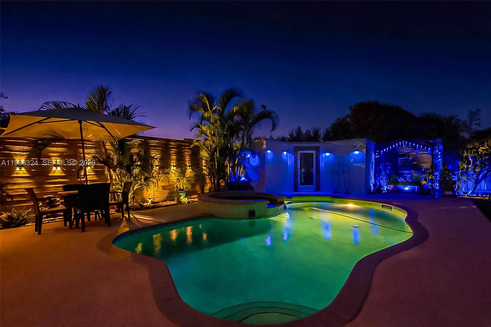 A backyard swimming pool and hot tub are illuminated at night with patio furniture nearby — 21040 SW 85th Pass, Cutler Bay FL 33189, CUTLER BAY, FL