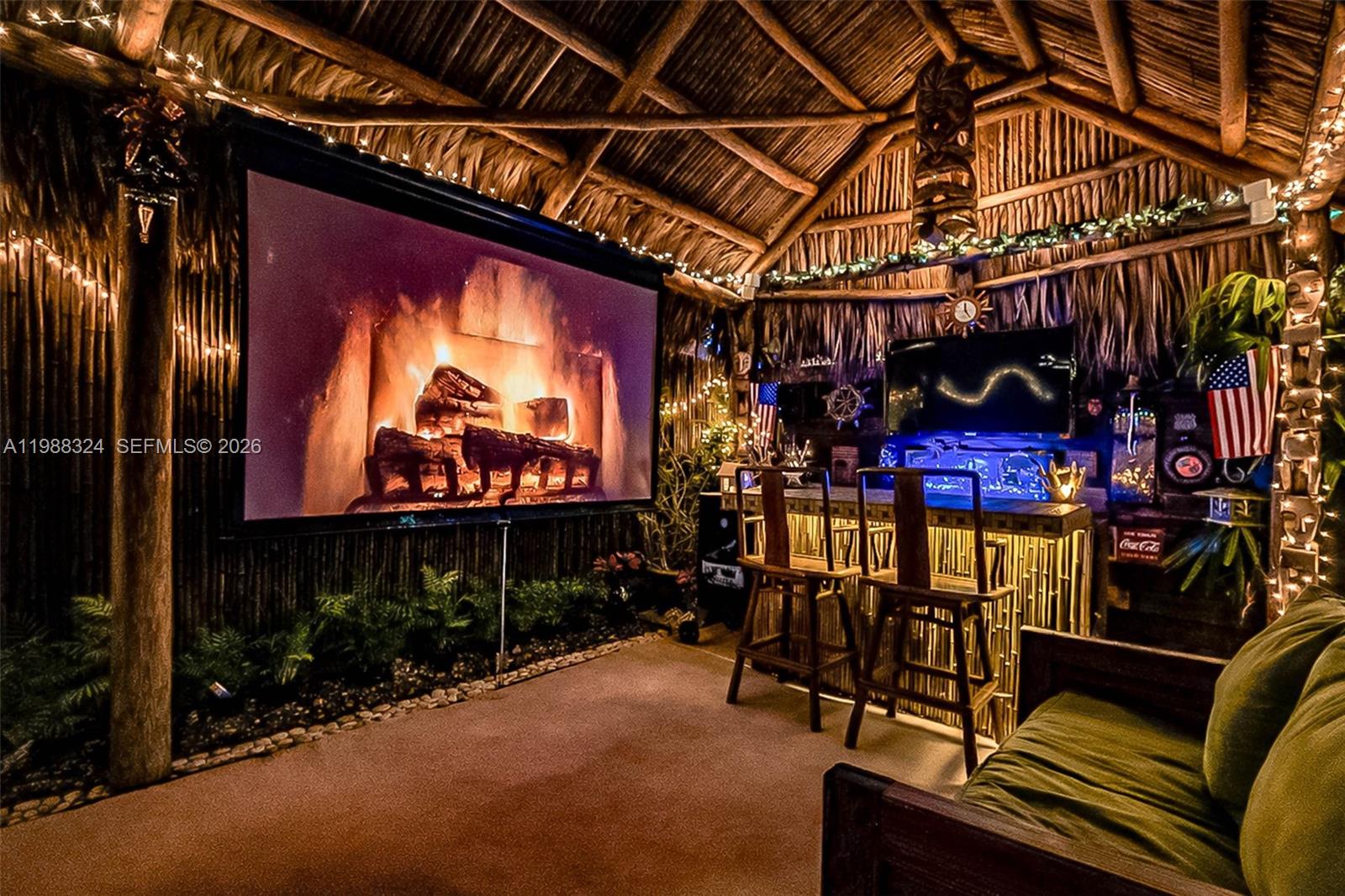 A tiki-style outdoor room features a large projector screen, a bamboo bar, and thatched roofing — 21040 SW 85th Pass, Cutler Bay FL 33189, CUTLER BAY, FL