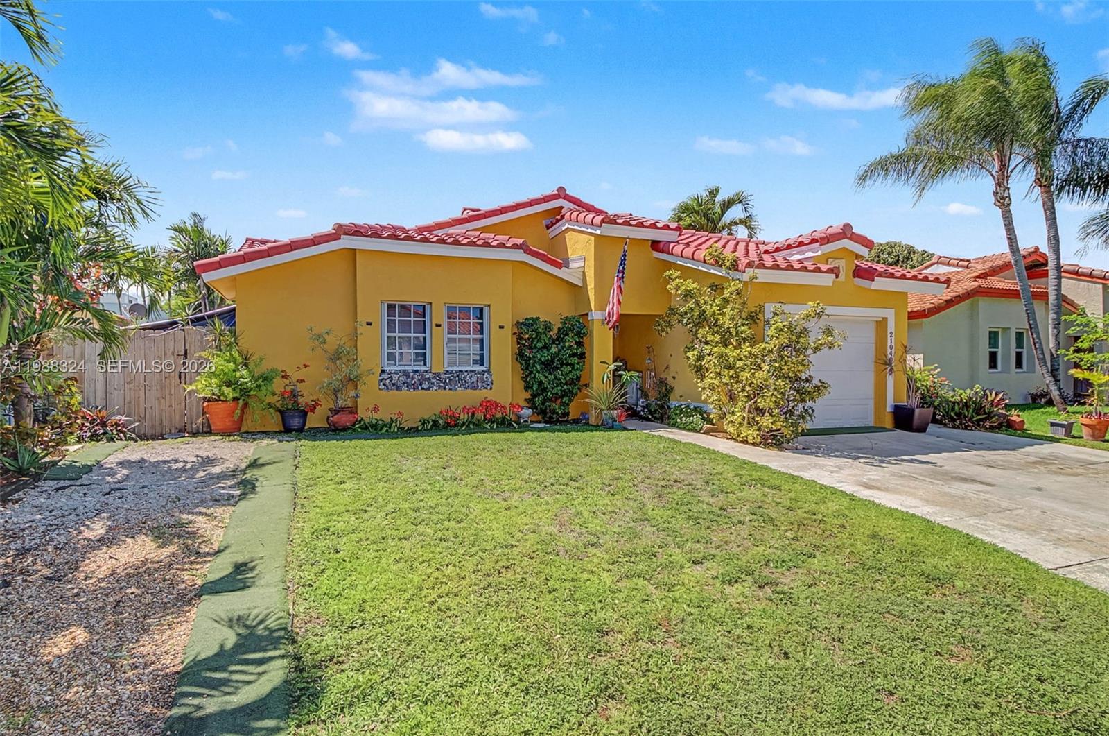A yellow single-story house features a red tile roof, a garage, and a front lawn — 21040 SW 85th Pass, Cutler Bay FL 33189, CUTLER BAY, FL