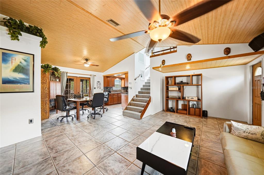 A living room with tile floors, a wooden vaulted ceiling, and stairs leading to a loft — 2631 FIESTA DRIVE, VENICE, FL
