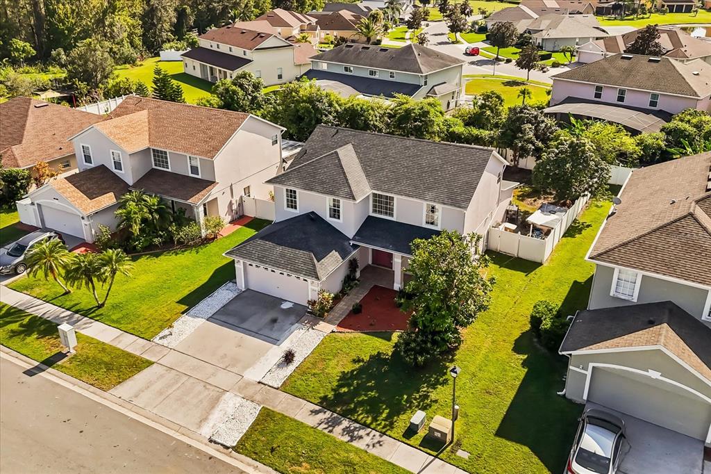 An aerial view shows a two-story suburban house with a gray roof and driveway — 2530 BAYKAL DRIVE, KISSIMMEE, FL