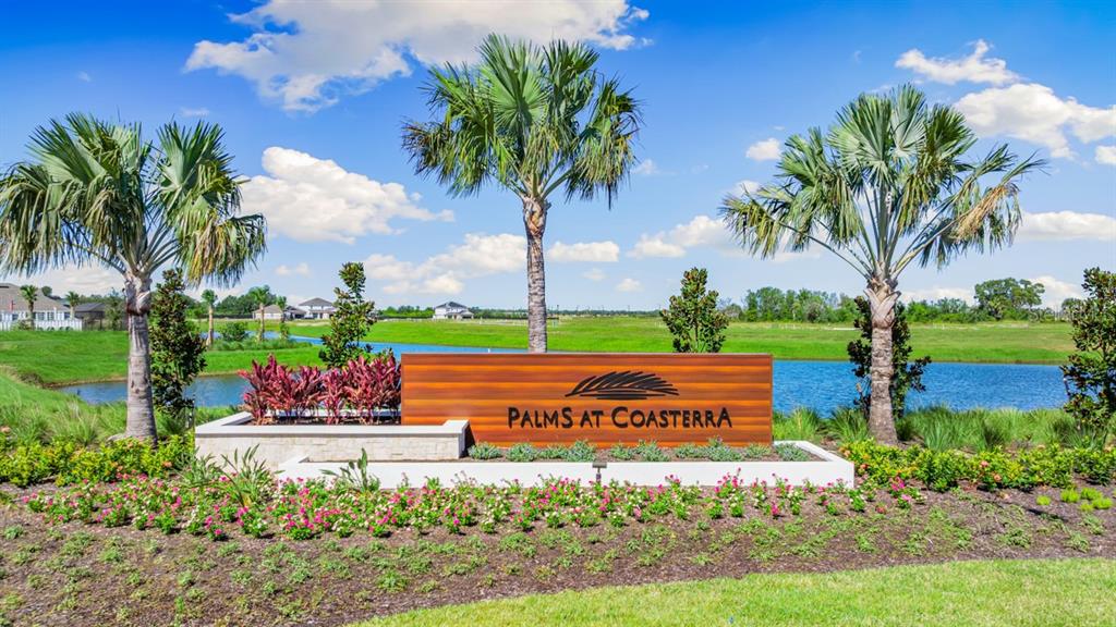 The entrance sign for Palms at Coasterra features palm trees, landscaping, and a pond — 12759 DOCKYARD TRAIL, PALMETTO, FL