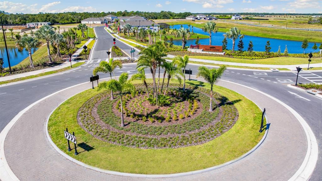 An aerial view of a landscaped roundabout with palm trees in a residential neighborhood — 12759 DOCKYARD TRAIL, PALMETTO, FL