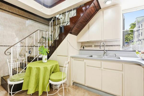 A kitchen features a small dining table under a wooden staircase with decorative metal railings — #9 MANUEL POLOP SOLER, UTUADO, PR