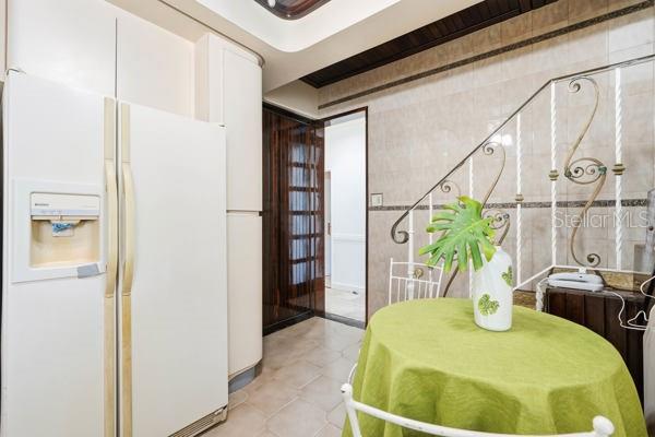A kitchen features a white refrigerator, a round green table, and a decorative metal railing — #9 MANUEL POLOP SOLER, UTUADO, PR