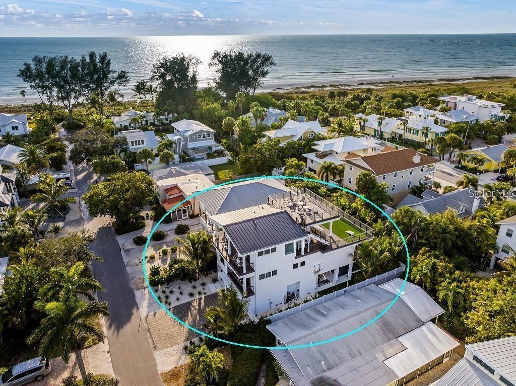An aerial view of a multi-story white house with a rooftop deck near the beach — 112 MAPLE AVENUE, ANNA MARIA, FL