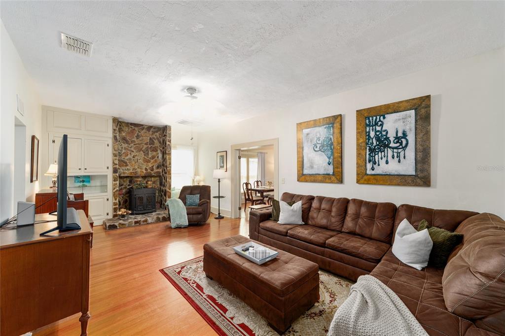A living room features a stone fireplace, brown sectional sofa, and hardwood flooring — 20693 WALNUT STREET, DUNNELLON, FL