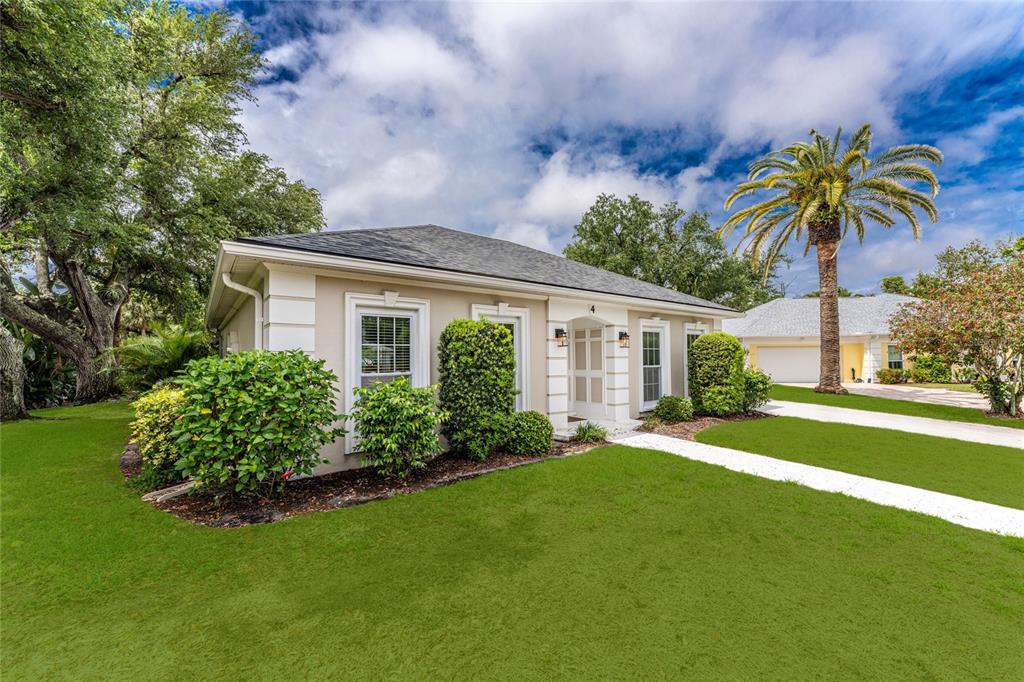 A single-story house with a beige exterior, white trim, and a palm tree in front — 4 CURACAO CIRCLE UNIT 40, ENGLEWOOD, FL