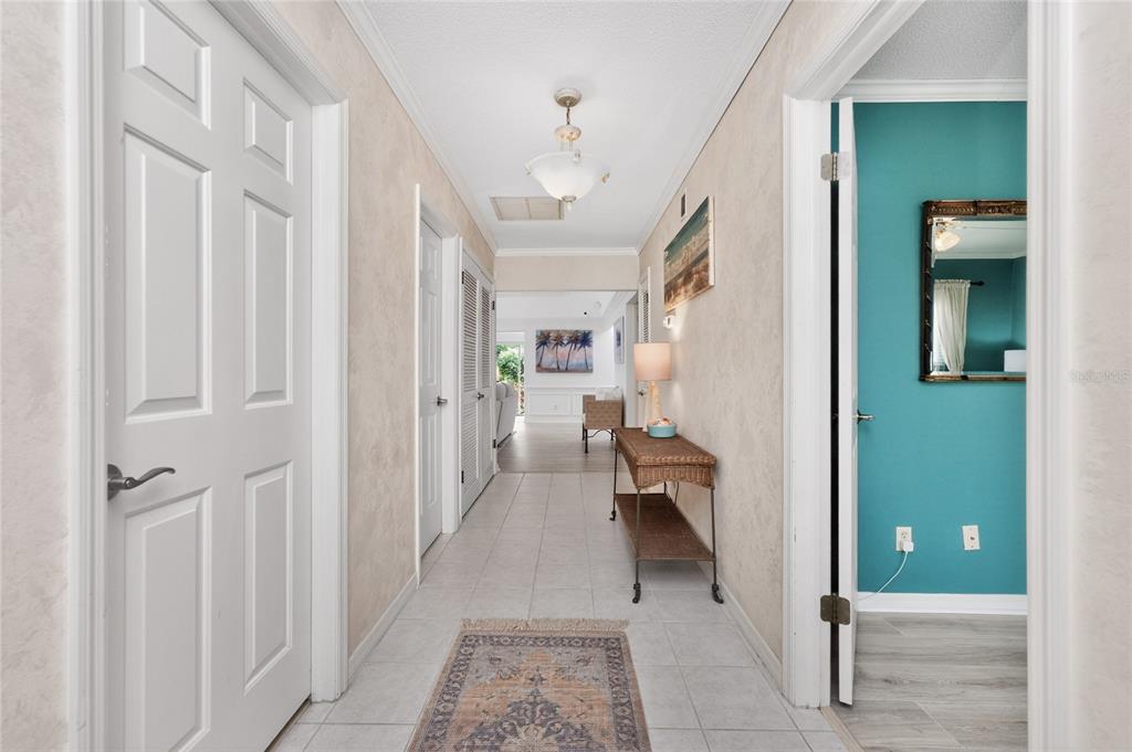 A tiled hallway leads to a living area, featuring beige walls and a side room — 4 CURACAO CIRCLE UNIT 40, ENGLEWOOD, FL