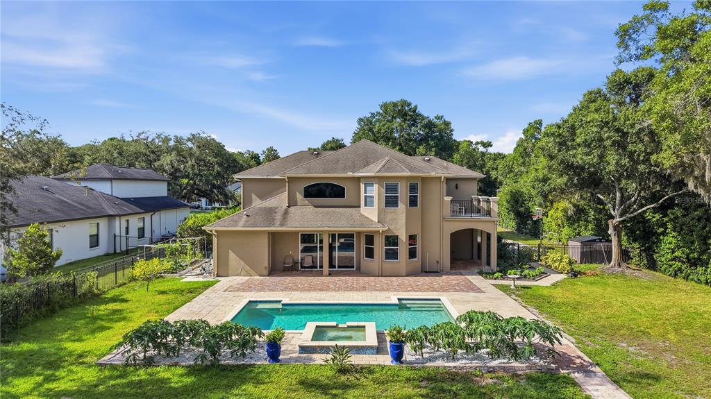 A two-story house with a backyard pool, patio, and surrounding lawn — 9244 RHEA DRIVE, ODESSA, FL
