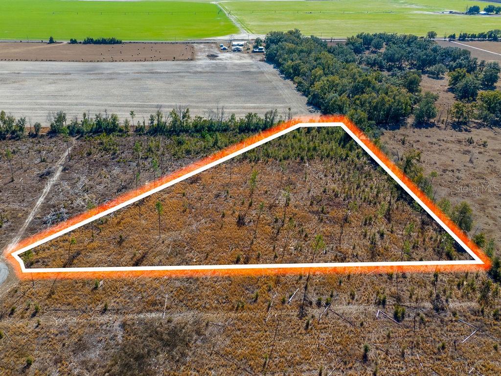 An aerial view shows a triangular plot of land outlined in white and orange — TBD 211TH COURT, LIVE OAK, FL