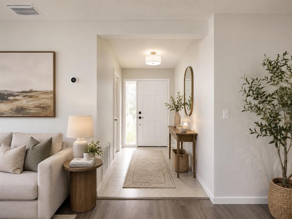 A bright entryway features a white front door, a console table, and a neutral rug — 378 BUTTONWOOD DRIVE, KISSIMMEE, FL