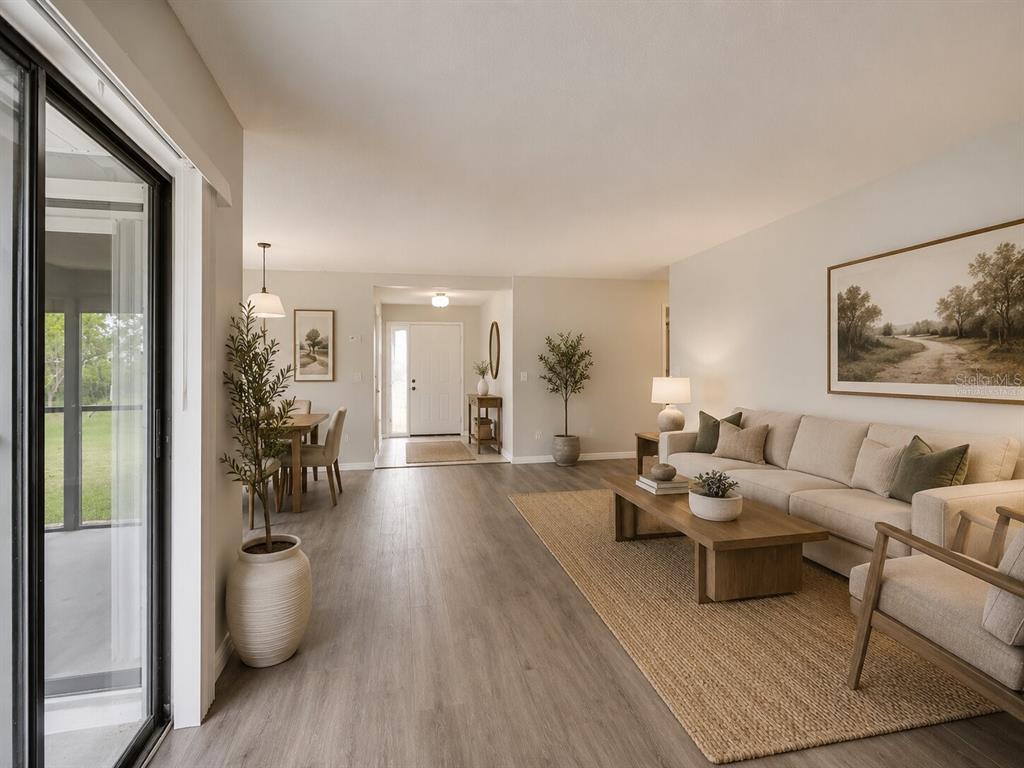 A living room and dining area feature light wood-look flooring and a neutral color palette — 378 BUTTONWOOD DRIVE, KISSIMMEE, FL