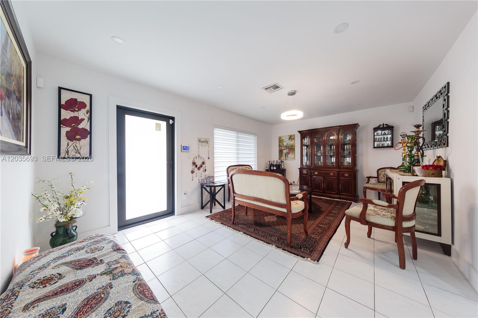 A living room features white tile floors, a dark wood hutch, and traditional furniture — 19311 Sterling Dr, Cutler Bay FL 33157, CUTLER BAY, FL