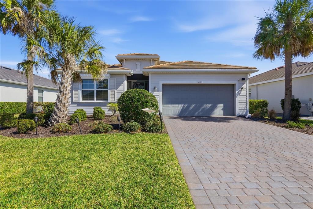 A single-story house with a paved driveway, a two-car garage, and palm trees — 15025 SPANISH POINT DRIVE, PORT CHARLOTTE, FL
