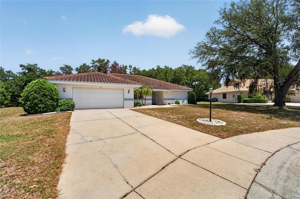 A single-story house with a white garage and a tiled roof sits on a lot — 2015 BERRY ROBERTS DRIVE, SUN CITY CENTER, FL